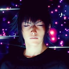 a young man with his eyes closed in front of colorful lights