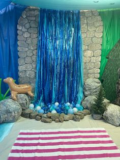 a room with blue and green decorations on the walls, rocks and streamers hanging from the ceiling