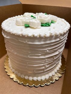 a white frosted cake sitting on top of a cardboard box