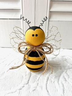 a yellow and black bee sitting on top of a white bed