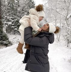 a woman holding a child in the snow