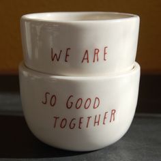 two white bowls with words written on them