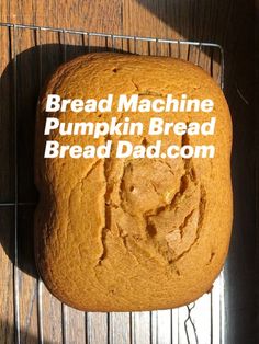 a loaf of bread sitting on top of a cooling rack with the words bread machine pumpkin bread