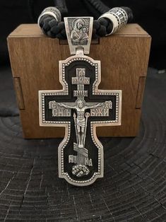 "Silver cross with ebony wood. Art. 0178 ✔️925 silver with blackening + ebony wood ✔️Size 80/39.6 mm ✔️Weight 54 grams ✔️The cross depicts: 🔘Jesus Christ 🔘Mother of God 🔘Nicholas the Wonderworker 🔘Vladimir the Great 🔘Panteleimon the Healer 🔘Guardian Angel ✔️On the end is the complete prayer \"Our Father\" ✔️Possible production in: 🟡Gold 14K or 18K (red, yellow, white) 🌕24K gold plated sterling silver 🔘Silver with blackening or rhodium Need more information? If you have any questions please don't hesitate to contact us!" Black Engraved Crucifix Necklace, Black Crucifix Necklace Engraved, Black Engraved Pendant Cross Necklace, Handmade Black Crucifix Necklace, Engraved Black Cross Necklace As Gift, Black Engraved Cross Necklace Gift, Handmade Black Cross Pendant Necklace, Engraved Black Cross Necklace For Gift, Gift Black Engraved Cross Necklace