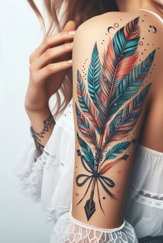 a woman's arm with feathers and arrows tattooed on the back of her shoulder