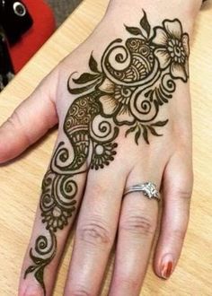 a woman's hand with henna tattoos on it