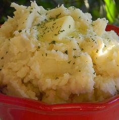 a red bowl filled with mashed potatoes on top of a table