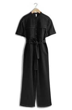 Contrast stitching amplifies the utilitarian vibes of a wide-leg jumpsuit tied with a matching belt. 30" inseam, 20" leg opening, 56" length (size Small) Front button closure Band collar Short sleeves Front patch pockets; side-seam pockets Removable tie belt 73% viscose, 23% polyamide, 4% elastane Dry clean Imported Black Summer Jumpsuit With Button Closure, Dark Wash Cotton Button-up Jumpsuits And Rompers, Black Long Sleeve Jumpsuit With Button Closure, Black V-neck Jumpsuits And Rompers With Pockets, Black V-neck Jumpsuit With Pockets, Short Sleeve Jumpsuit, Short Sleeve Jumpsuits, Band Collar, Wide Leg Jumpsuit