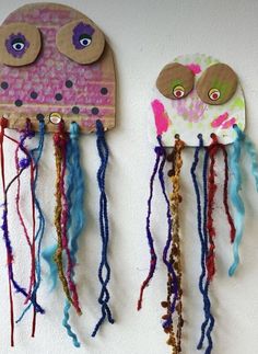 two paper plate jellyfishs are hanging on the wall