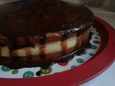 a chocolate cake with white frosting on a red plate