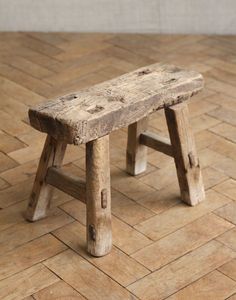 a wooden bench sitting on top of a tiled floor