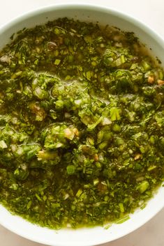 a white bowl filled with green vegetable soup