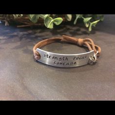 a bracelet with the words strength, love and courage engraved on it