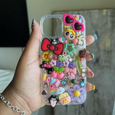 a person holding a cell phone case with many different items on the front and back