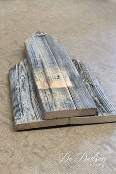 two pieces of wood sitting on top of a floor next to each other, one is made out of old planks