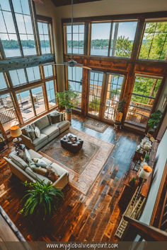 A stunning lakefront Airbnb in Maryland featuring a spacious living area with floor-to-ceiling windows, rustic wooden floors, cozy couches, and panoramic views of a serene lake surrounded by lush greenery.