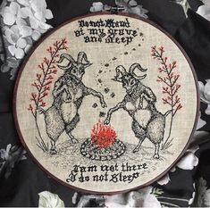 two sheeps are touching each other in front of a cross - stitch hoop with words on it