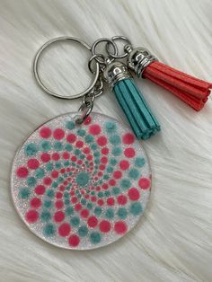 a keychain with a circular design and tassels