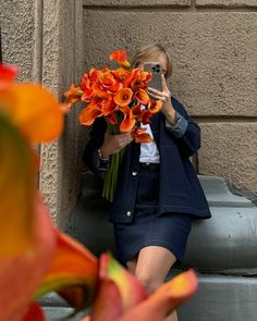 a woman taking a selfie with her cell phone and flowers in front of her