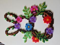 an image of a cross stitch pattern with flowers and leaves on the side of it