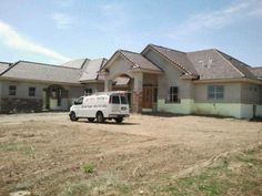 a white van parked in front of a house with lots of dirt on the ground