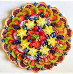 a colorful fruit salad with kiwis, strawberries, oranges and blueberries