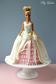 a barbie doll sitting on top of a cake