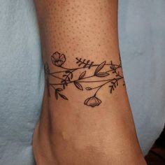 a woman's foot with a flower tattoo on the side of her leg,