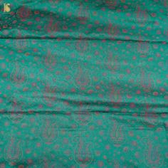 the fabric is green with pink and blue designs on it