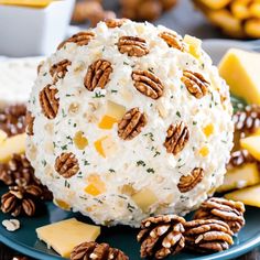 a cheese ball on a plate with pecans around it