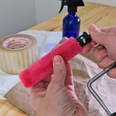 a person is using a sponge to clean a piece of paper with a sprayer