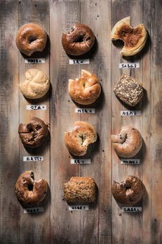 an assortment of different types of doughnuts displayed on a wooden board with numbered labels