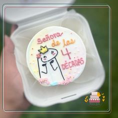 a decorated cookie in the shape of a bride and groom on top of a plastic container