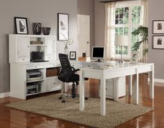 a white desk and chair in a room with wood flooring, framed pictures on the wall