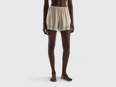 Flowy shorts with loose fit. High edge with clashing lace at the bottom. Made of sustainable viscose, produced using wood from certified forests and respecting the highest environmental standards. Beige Pajama Shorts With Elastic Waistband, Beige Summer Pajama Shorts, Beige Elastic Waistband Pajama Shorts, Fitted Beige V-neck Sleepwear, Beige Beachwear Bottoms With Built-in Shorts, Shorts Flowy, Shorts With Lace, Flowy Shorts, Mini Shorts