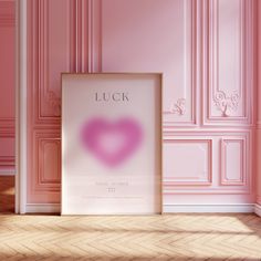 a pink room with a framed poster on the floor and an image of a heart