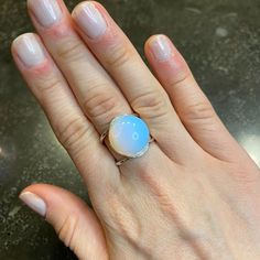 Embrace The Magic Of The Moon With Our Moonstone Dome Ring. This Unique Ring Features A Mesmerizing Moonstone Opalite Gem, Perfect For Adding A Touch Of Whimsy To Any Outfit. Let The Moon Guide Your Style. (Moon Not Included). Adjustable To Fit Sizes 5.5 Through 9.5. Made Of: Moonstone Opalite Silver Plating (7-10 Microns) Over Brass Made In Brazil Disclaimer: Please Note That All Semiprecious Stones Have Imperfections And Are Part Of Their Own Beauty. Due To Changes In Lighting, A Product May A Adjustable Polished Moonstone Ring, Adjustable Spiritual Moonstone Ring, Mystical Cabochon Moonstone Ring, Adjustable Blue Cabochon Moonstone Ring, Spiritual Adjustable Moon-shaped Moonstone Ring, Moonstone Jewelry, Domed Ring, White Silver, Adjustable Rings