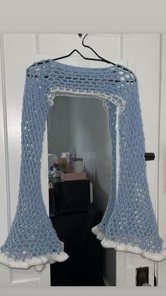 a crocheted blue blanket hanging from a door