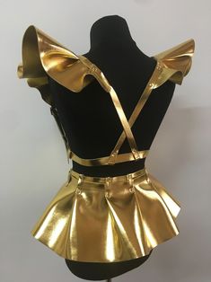 a mannequin dressed in gold and black with bows on it's back