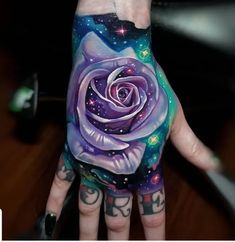 a person's hand painted with an image of a rose and stars on it