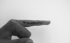 someone has written the word shame on their finger