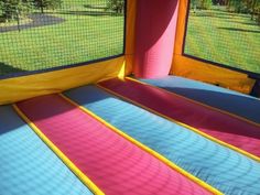 an inflatable bounce house with pink and blue stripes