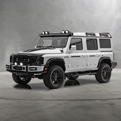 a white hummer truck parked on top of a cement floor next to a wall