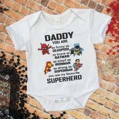 White Short Sleeve Onesie With Daddy Is My Superhero Design To Front. Marvel Baby Clothes, Superhero Onesie, Gender Neutral Kids Clothes, My Superhero, Enhypen Niki, Boutique Baby, Baby Unisex, Girl Superhero, Girl Onesies