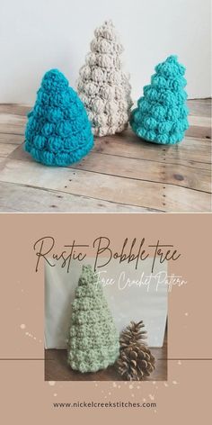 three crocheted christmas trees sitting on top of a wooden table next to each other