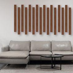 a modern living room with white leather furniture and wood panels on the wall behind it