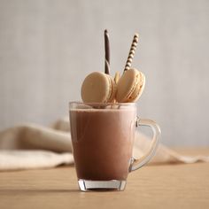 a cup filled with chocolate and cookies on top of a table