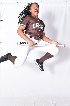 a female baseball player is jumping in the air