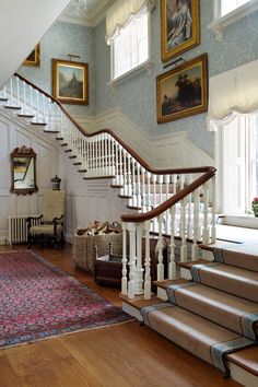 a staircase in a house with pictures on the wall and carpeted stairs leading up to the second floor