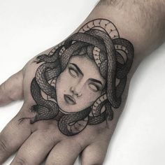 a woman's hand with a tattoo on it and a snake around her wrist